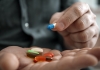 A man hands containing pills