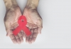 Man holding red aids ribbon, HIV/AIDS 