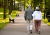 Elderly couple walking arm in arm in a park