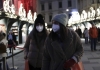 two masked people walk in a night market