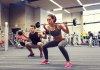 A woman and man lifting weights in a gym