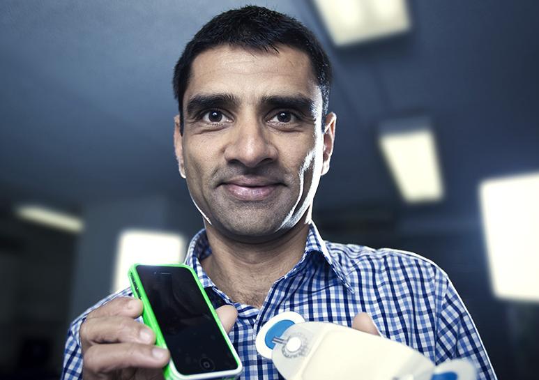 Associate Professor Vijay Sivaraman holds a wearable ECG monitoring device.